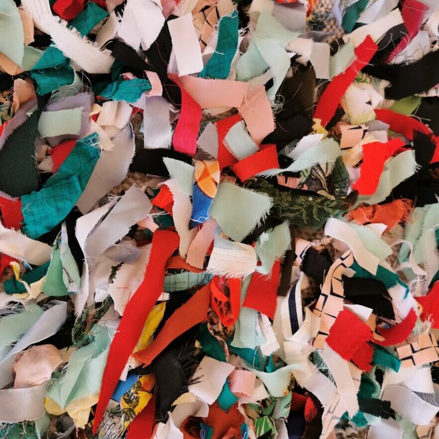A vibrant collage of fabric scraps creates a colorful abstract texture.